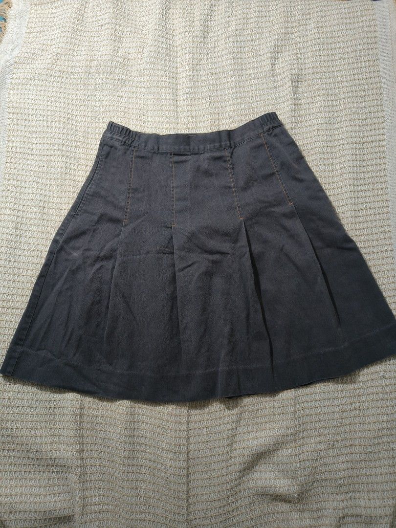 Grey Pleated Mid Skirt with Button and Zipper (Category: Skirts) located in Paranaque City. Submitted by vichhichi_ocean (Listing ID 1464813064, Image 1). Description: - Color: Dark grey with contrast stitching - Style: Mid length, above knee-level, textured weave - Details: Front pleats, zipper, and button at the back with side pockets - Versatility: Great for casual days and layering.