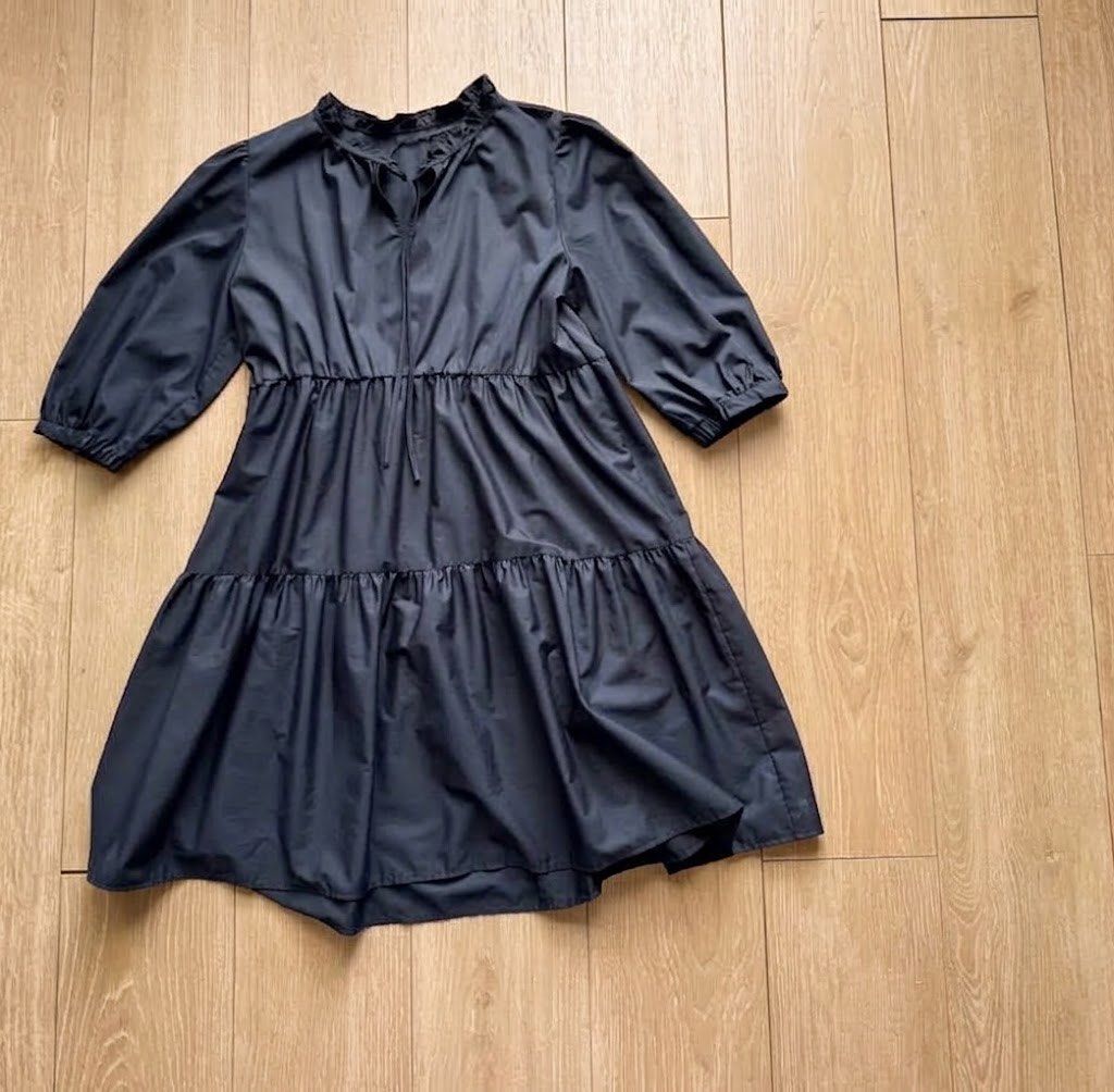 GU black tiered dress (Category: Dresses) located in Cabanatuan. Submitted by tal_0000 (Listing ID 1464868675, Image 2). Description: - Color: Black - Design: Tiered dress with a dropped waistline and above-the-knee length - Sleeves: Mid-length with elastic cuffs - Neckline: Ruffle collar with front tie string.