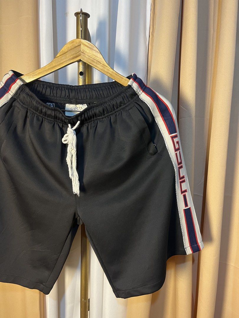 Gucci Black Track Shorts with Side Stripe (Category: Shorts) located in Kidapawan. Submitted by azythrift (Listing ID 1464916041, Image 2). Description: - Authentic Gucci shorts made in Italy - Color: Black with signature red, blue, and white side stripes featuring GG logo details - Waistband: Comfortable white drawstring - Fit: Relaxed fit, perfect for stylish casual streetwear - Condition: Includes original interior brand tag and care labels - 