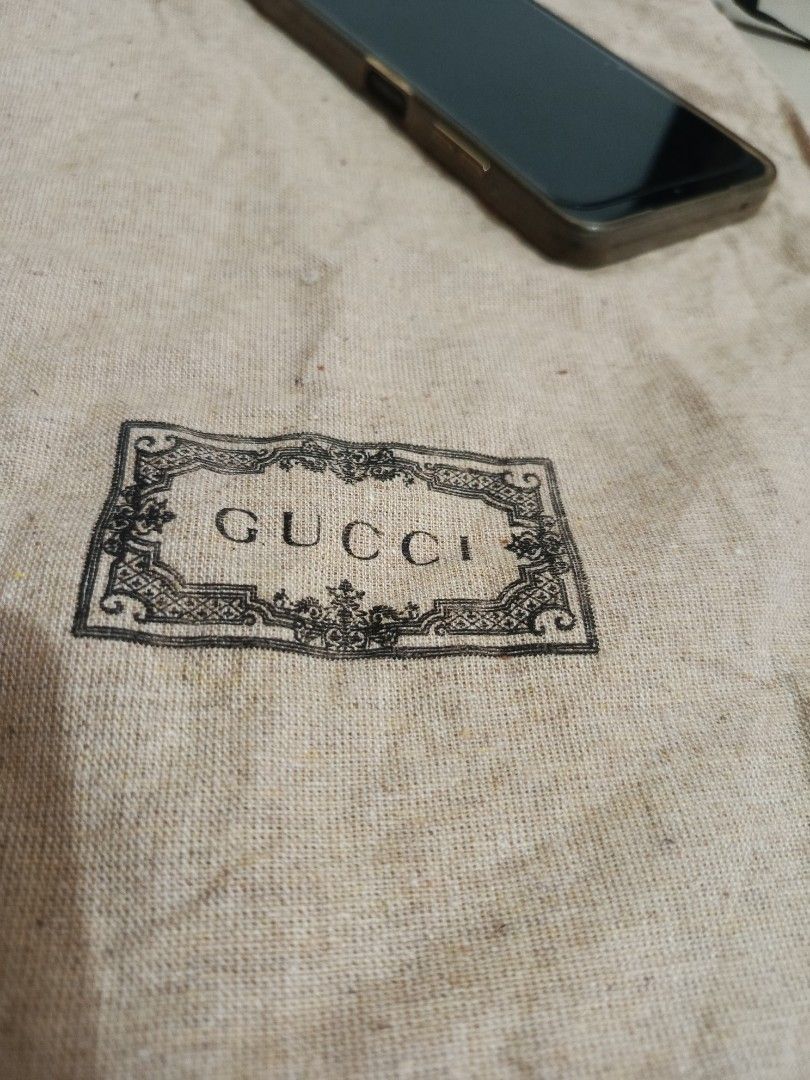 Gucci branded dust bag with drawstring (Category: Luxury Bags & Wallets) located in Irosin. Submitted by whanchore55263 (Listing ID 1464781090, Image 2). Description: - Authentic vintage-style Gucci dust bag - Crafted from beige linen-texture fabric with a classic centered logo in an ornate frame - Features a secure black drawstring closure at the top - Includes an interior Global Recycled Standard (GRS) tag from ICEA L16.5x11.5 inches .