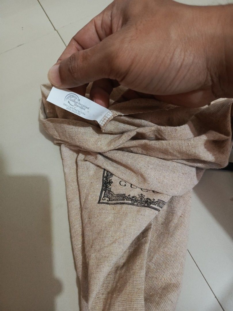Gucci branded dust bag with drawstring (Category: Luxury Bags & Wallets) located in Irosin. Submitted by whanchore55263 (Listing ID 1464781090, Image 3). Description: - Authentic vintage-style Gucci dust bag - Crafted from beige linen-texture fabric with a classic centered logo in an ornate frame - Features a secure black drawstring closure at the top - Includes an interior Global Recycled Standard (GRS) tag from ICEA L16.5x11.5 inches .
