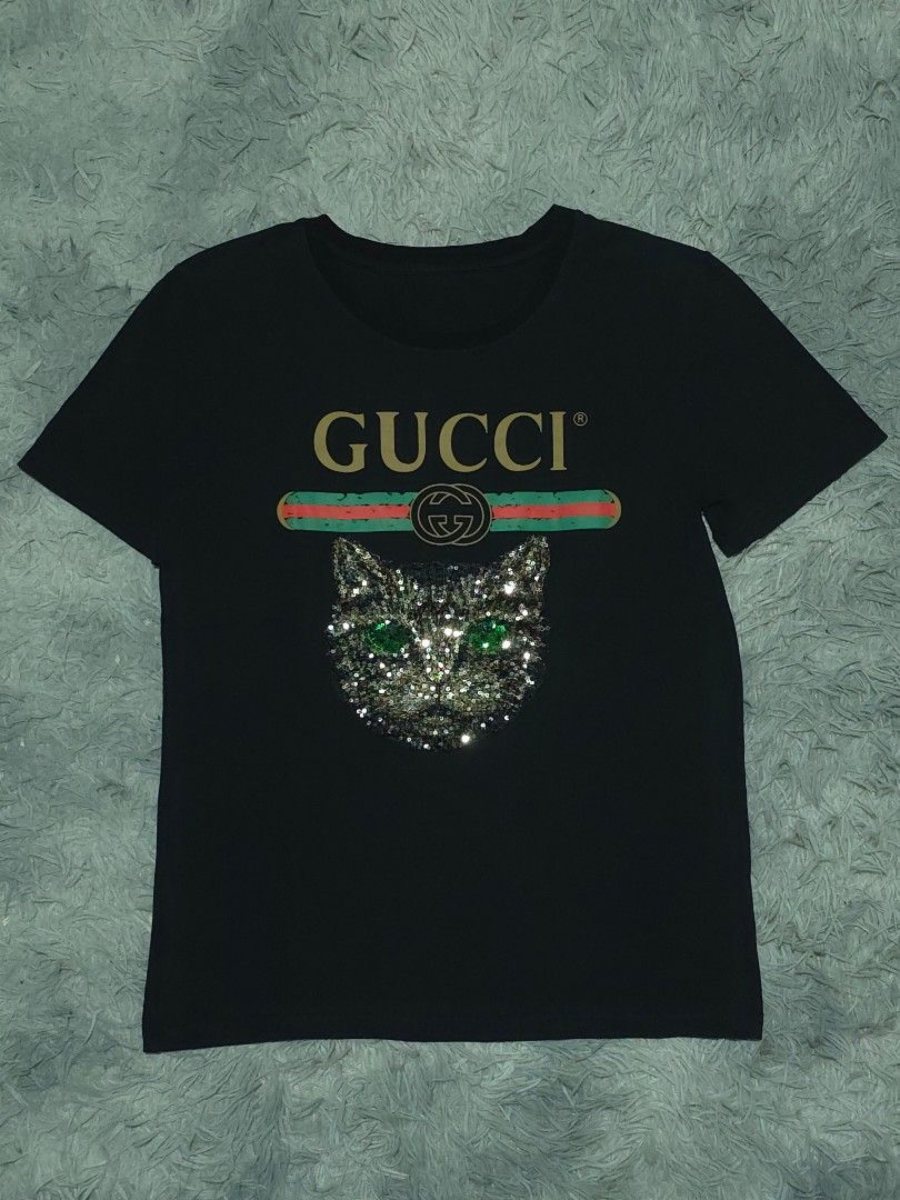 Gucci Sequin Cat (Category: Shirts) located in Abulug. Submitted by humanwhosellthings (Listing ID 1464895788, Image 1). Description: GUCCI Sequin Cat Womens Tee ✅️Size: Medium ✅️Dimes: 18W x 25.5L ✅Condition: Very Good - Excellent ✅Issue: None,missing necktag only ✅Color Rate: 9.2/10.