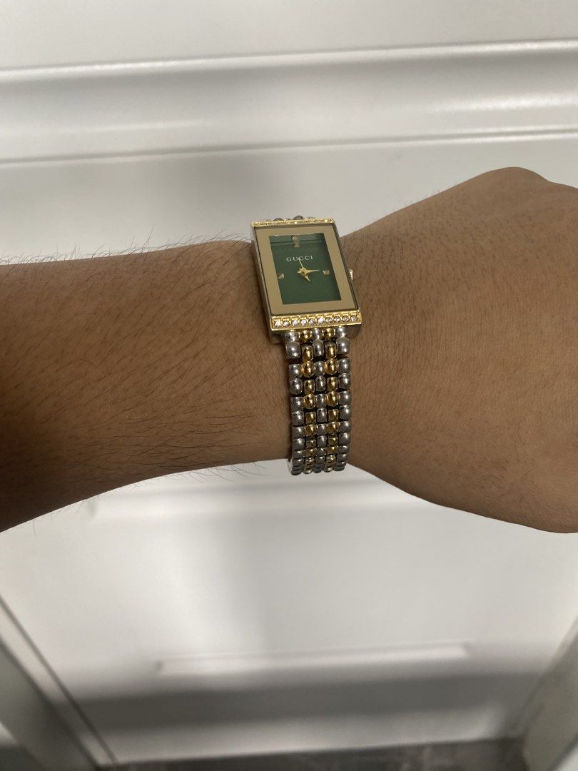 Gucci Two-Tone Rectangular Green Dial Watch No. C8653 (Category: Luxury Watches) located in Pasig City. Submitted by silentgem-ac4d (Listing ID 1464920819, Image 3). Description: - Brand: Gucci vintage dress watch - Dial: Striking green textured dial with gold hands and markers - Bracelet: Two-tone silver and gold steel bracelet with secure clasp - Bezel: Accented with small crystal stones at the top and bottom - Caseback: Stainless steel stamped