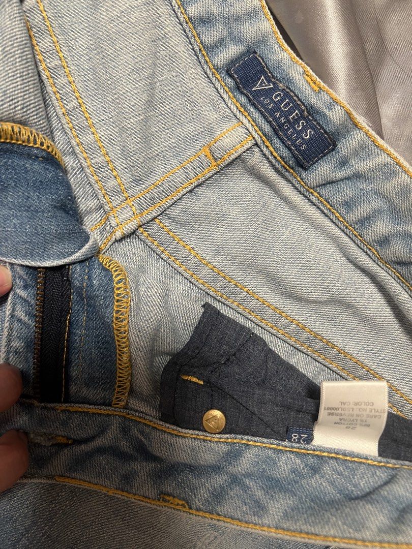 Guess Denim Shorts Size 28 (Category: Shorts) located in Makati City. Submitted by warm.abc123 (Listing ID 1464877392, Image 3). Description: Authentic GUESS - Size: 28 - Color/Wash: Light blue wash - Closure: Button fly with branded hardware - Details: Frayed raw hem, classic five-pocket design, contrast yellow stitching - Branding: Small metal GUESS triangle logo on the back pocket - Condition: Excellent pre-loved condition, ready to wear!.