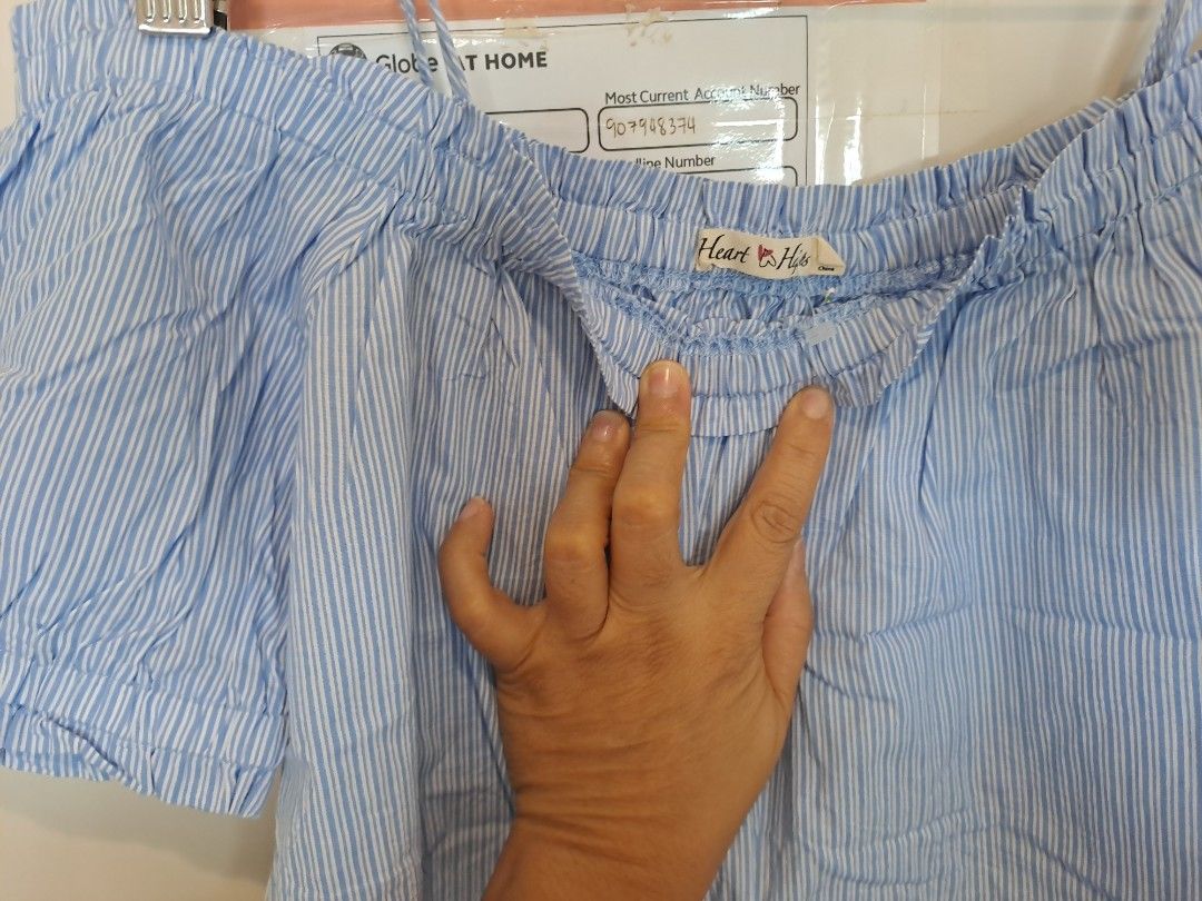 Heart and hips off shoulder blouse (Category: Blouses) located in Manila. Submitted by joanbalde39643 (Listing ID 1464791998, Image 2). Description: This is an off-the-shoulder pinstriped blouse from the clothing brand Heart & Hips. It features light blue and white vertical stripes, short ruffled sleeves, and an elasticated smocked neckline..