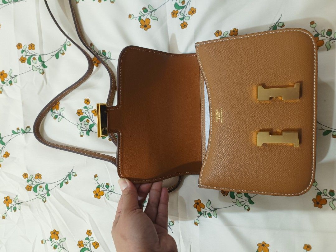 Hermes Constance Gold Epsom Leather Handbag (Category: Luxury Bags & Wallets) located in Baguio. Submitted by maria.s0329822318 (Listing ID 1464785791, Image 2). Description: - Brand: Hermes - Model: Constance - Material: Epsom leather - Color: Gold Brown (warm tan) - Hardware: Gold-tone H clasp and strap loops - Interior: Hermes Paris gold foil stamp - Details: Contrast white saddle stitching, adjustable shoulder strap, structured rectangular bo
