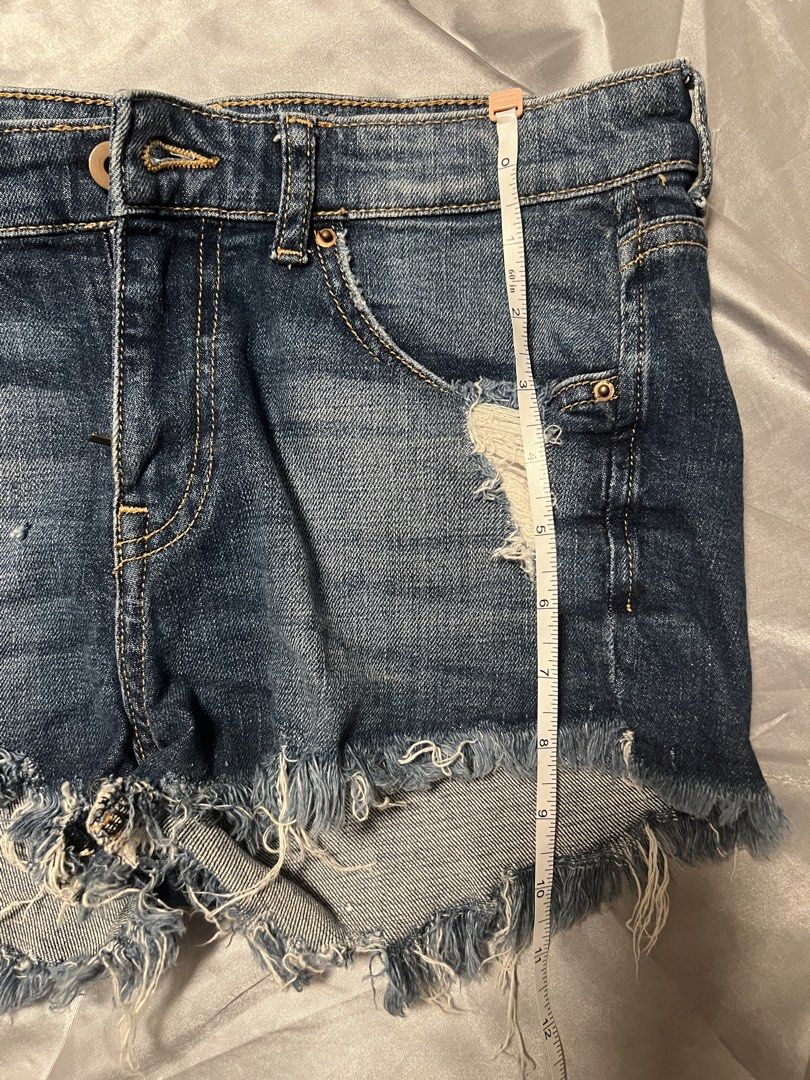 H&M Distressed Denim Shorts Size US 4 (Category: Shorts) located in Makati City. Submitted by warm.abc123 (Listing ID 1464877720, Image 3). Description: - Brand: H&M - Size: EUR 34 / US 4 - Wash: Classic dark wash denim with contrast yellow stitching - Fit: Low-rise with front button and zipper closure - Details: Heavy distressing, ripped front and back pocket, trendy raw frayed hems - Condition: Great everyday piece for warm weather.