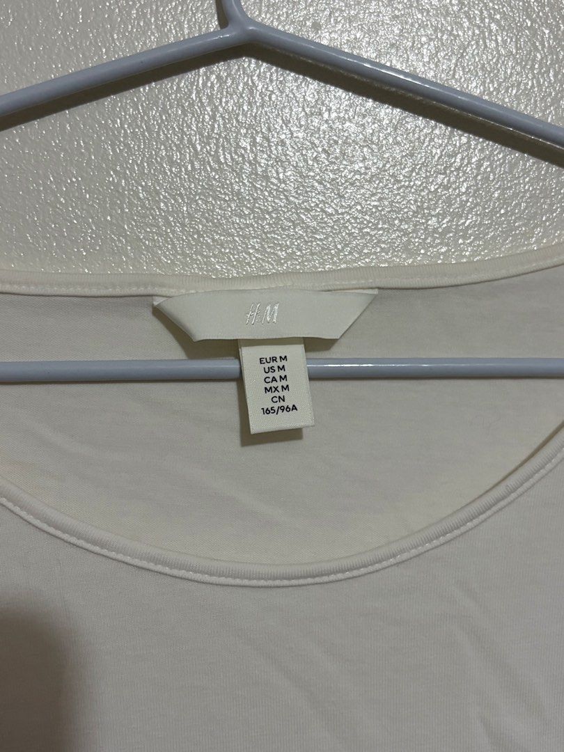 H&M White Ruched Side T-Shirt (Category: Shirts) located in Cainta. Submitted by knarv__ (Listing ID 1464883643, Image 2). Description: H&M white t-shirt in size M, featuring short sleeves, a round neckline, and flattering ruched details on the sides. Made from soft stretch cotton, perfect for easy everyday styling..