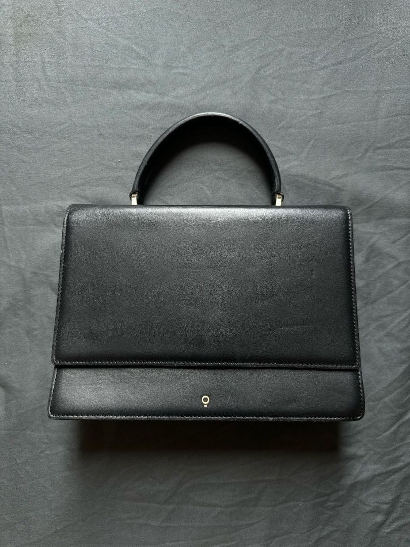HOZE Black Leather Top Handle Handbag (Category: Tote Bags) located in Manila. Submitted by shopwmsl123 (Listing ID 1464786334, Image 1). Description: - Brand: HOZE - Color: Black with gold-tone hardware - Style: Structured minimalist handbag with top handle - Design: Accordion-style gusset and flap closure with front gold emblem - Compartments: Multiple inside compartments plus a back pocket with brand stamp - Condition: Clean exterior and inter
