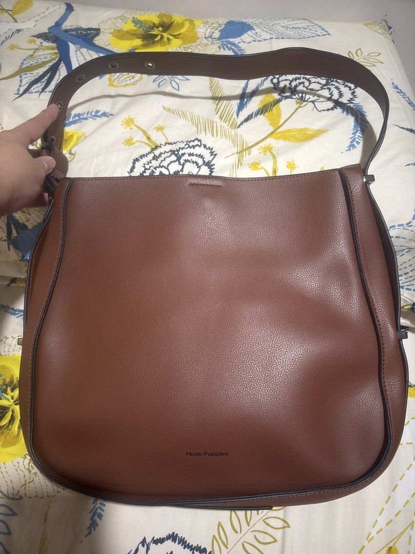 Hush Puppies Brown Shoulder Bag (Category: Shoulder Bags) located in Quezon City. Submitted by relyncabubas (Listing ID 1464782942, Image 1). Description: - Brand: Hush Puppies - Material: Textured faux leather in brown - Strap: Adjustable with stylish metal buckle details - Closure: Secure zip and magnetic snap main compartment - Interior: Clean black fabric lining - Condition: Clean exterior and interior, great for everyday use.