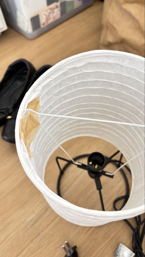 IKEA Paper Lantern Table Lamp with Black Base (Category: Lighting) located in Marikina City. Submitted by majojojojoe (Listing ID 1464833652, Image 3). Description: - Design: Cylindrical paper lantern on a sleek black metal wire base - Ambiance: Emits a warm, cozy glow ideal for bedside tables or desks - Power: Standard power cord equipped with an easy-to-use inline switch and plug - Condition: Fully functional; minor imperfection with one small 