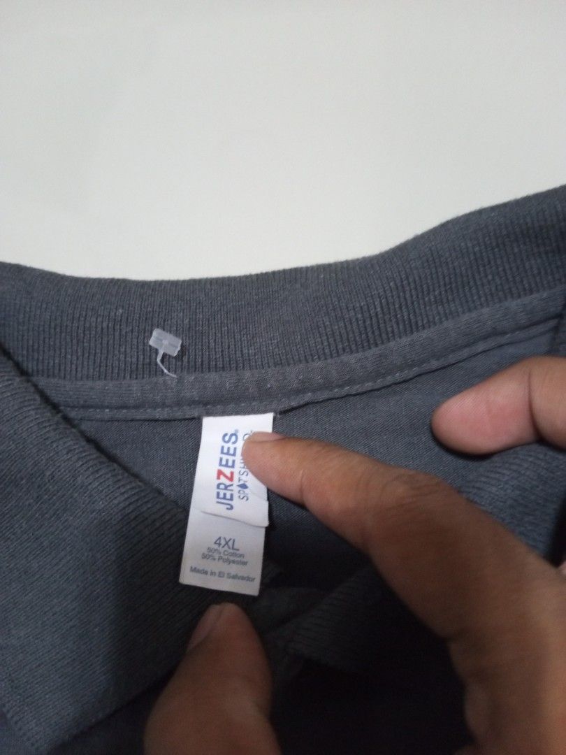 Jerzees polo shirt 4XL dark grey (Category: Tshirts & Polo Shirts ) located in Magdalena. Submitted by magdalenathrift20 (Listing ID 1464909887, Image 3). Description: - Brand: Jerzees - Color: Dark Grey - Size: 4XL (Width: 30 inches, Length: 33 inches) - Material: 50% Cotton, 50% Polyester blend - Condition: Brand new with tag attached - Features: Classic collar with two-button closure, short sleeves - Origin: Made in El Salvador.