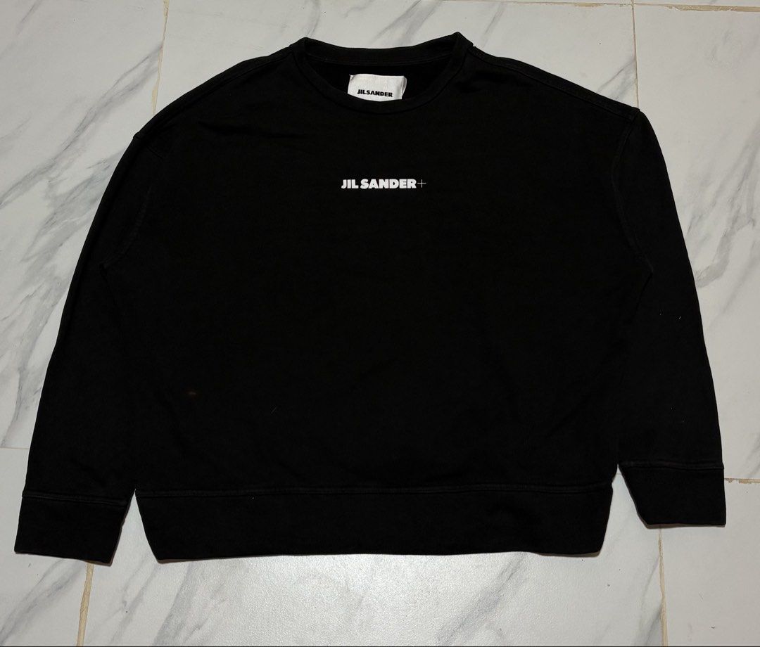 Jil Sander+ Black Logo Sweatshirt (Category: Coats, Jackets and Outerwear) located in Baguio. Submitted by thriftedbaguio (Listing ID 1464831635, Image 1). Description: Excellent Condition Size Large Tagged Dimensions 25*25 Color rate 10 - Brand: Jil Sander+ - Color: Black - Material: 100% heavy cotton - Origin: Made in Italy - Design: Classic crewneck with subtle white chest logo - Details: Ribbed cuffs and hem - Condition: Clean, premium piece.