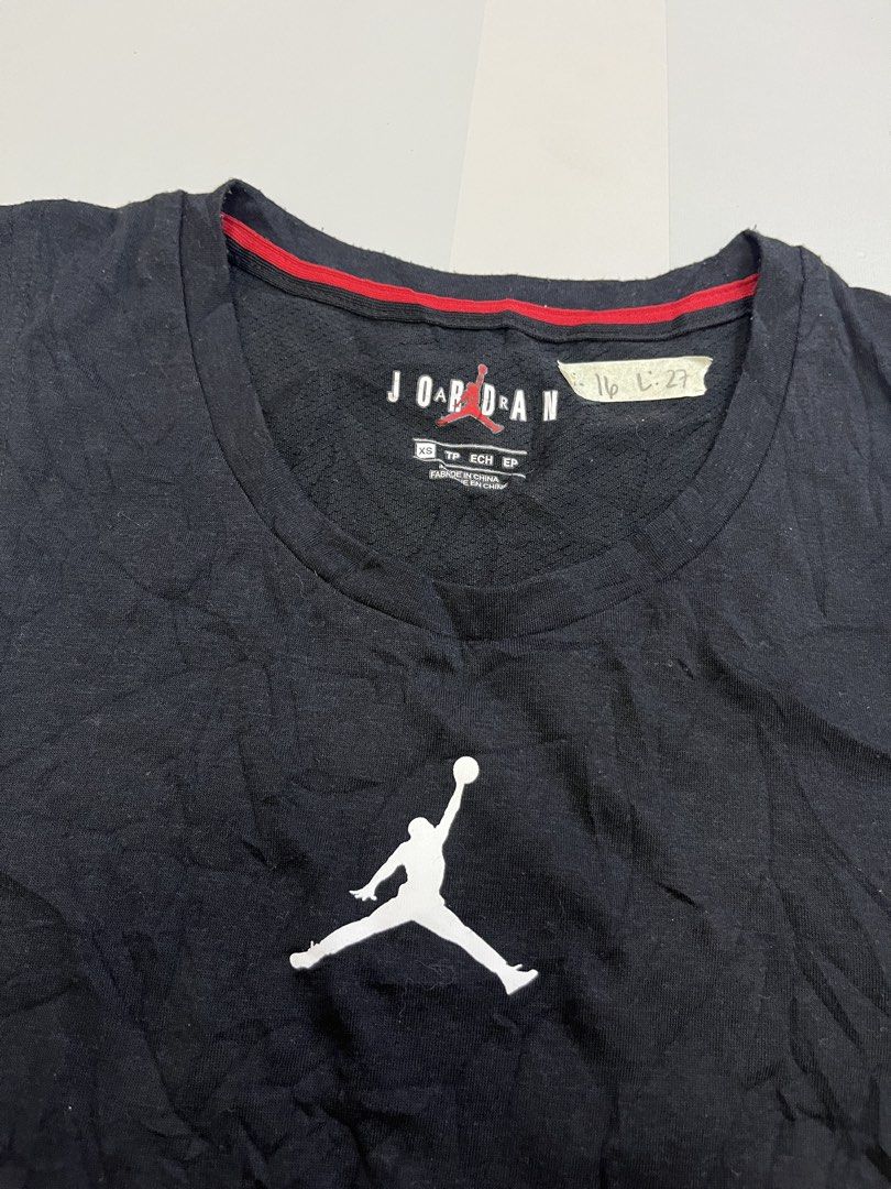 Jordan Black Jumpman Tank Top (Category: Activewear) located in Mabalacat. Submitted by aas_thriftfings (Listing ID 1464785273, Image 3). Description: - Brand: Jordan - Style: Sleeveless Tank Top - Size: XS - Style Code: CJ5545-010 - Color: Black with white Jumpman logo and red collar piping - Features: Back mesh hem with large stitched white JORDAN lettering - Material: Sustainable blend of recycled polyester, organic cotton, and rayon - Conditi