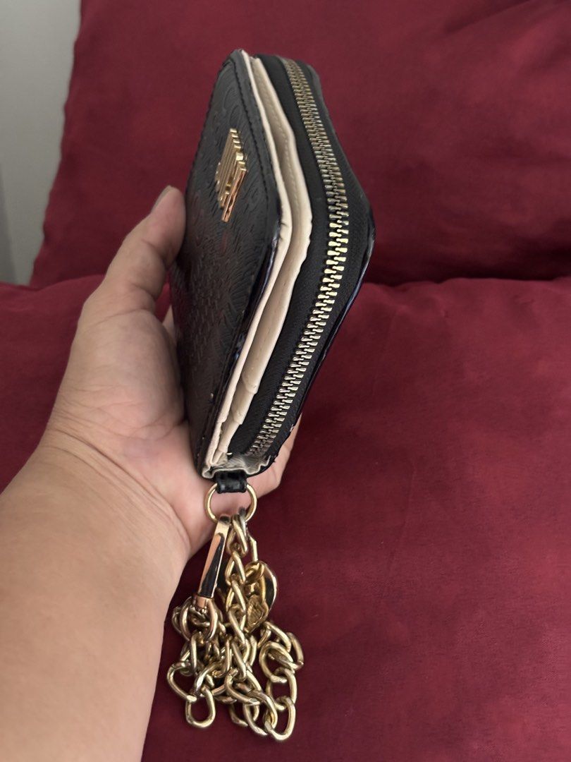Juicy Couture Black Embossed Wallet with Chain Strap (Category: Wallets & Card holders) located in Manila. Submitted by livfindsph (Listing ID 1464808469, Image 3). Description: Black Juicy Couture wallet with debossed lettering all over the exterior. Gold-tone logo lettering on the front. Includes a detachable gold chain strap with a heart charm. Snap-closure interior holds multiple cards, plus a clear ID window. Main compartment zips shut all t