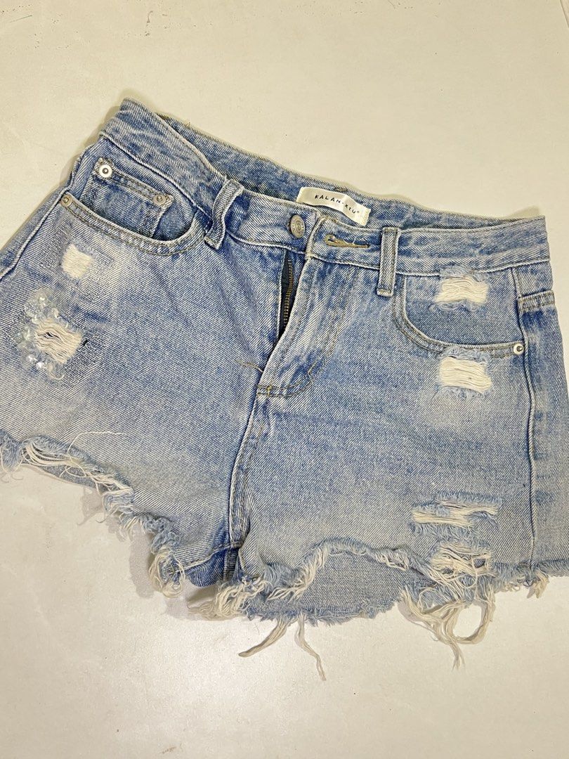 Kalan Xiu Distressed Denim Shorts (Category: Shorts) located in Manila. Submitted by sennisen (Listing ID 1464913169, Image 1). Description: - Brand: Kalan Xiu - Style: High-waisted light wash denim shorts - Details: Heavy distressing, ripped accents near pockets, and frayed raw hem - Design: Classic 5-pocket layout with contrast stitching and secure button/zipper fly - Condition: Brand new / Excellent (Ready to ship!) - Perfect for: Casual summe