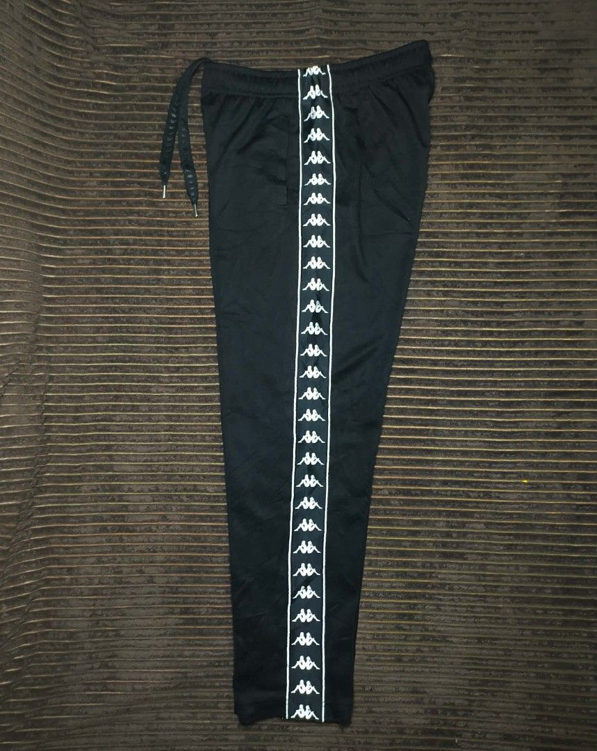 Kappa Black Track Pants with Side Tape Logo Size Medium (Category: Joggers) located in Manila. Submitted by norathrifted (Listing ID 1464799224, Image 2). Description: - Authentic Kappa track pants in classic black - Size: Medium (with red brand tag) - Iconic Omni logo taped down both legs - Elastic waistband with adjustable drawstring and metal tips - Deep and convenient side pockets - Soft, premium fabric ideal for lounging or workouts.