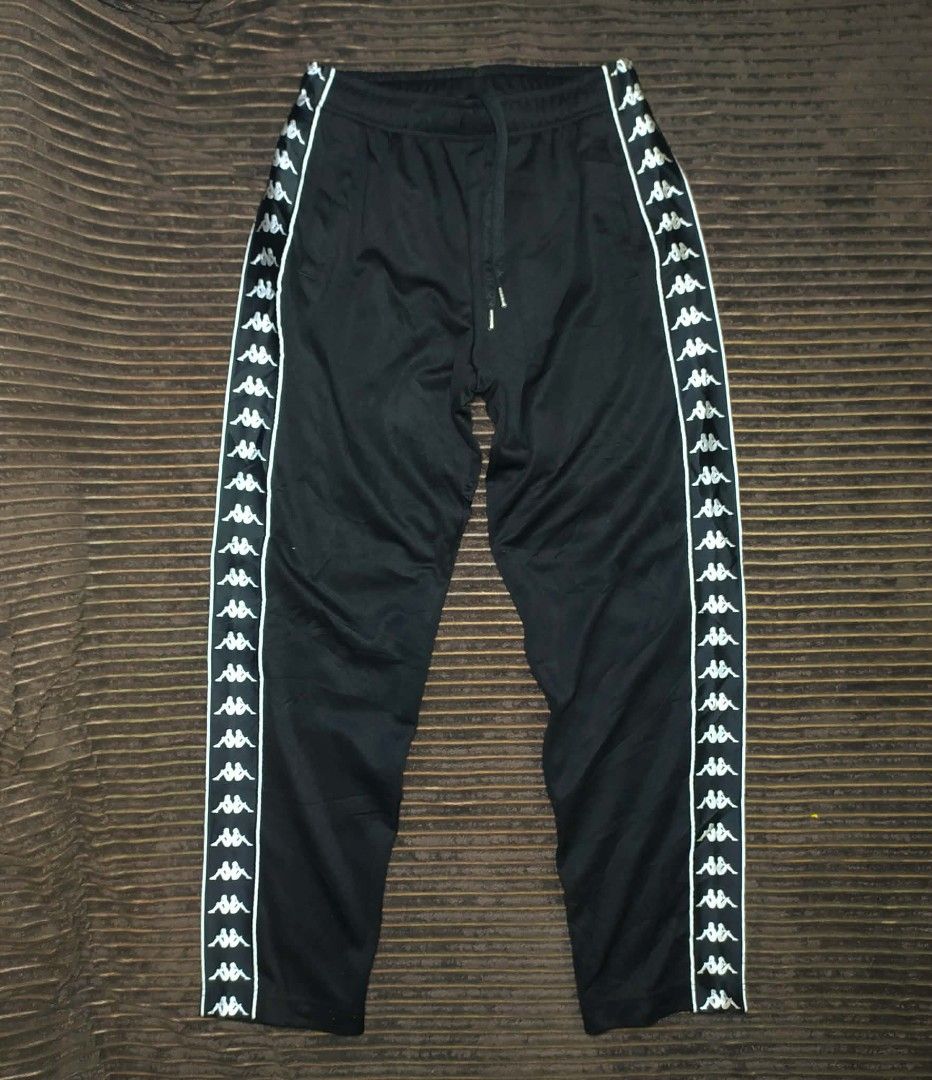 Kappa Black Track Pants with Side Tape Logo Size Medium (Category: Joggers) located in Manila. Submitted by norathrifted (Listing ID 1464799224, Image 3). Description: - Authentic Kappa track pants in classic black - Size: Medium (with red brand tag) - Iconic Omni logo taped down both legs - Elastic waistband with adjustable drawstring and metal tips - Deep and convenient side pockets - Soft, premium fabric ideal for lounging or workouts.