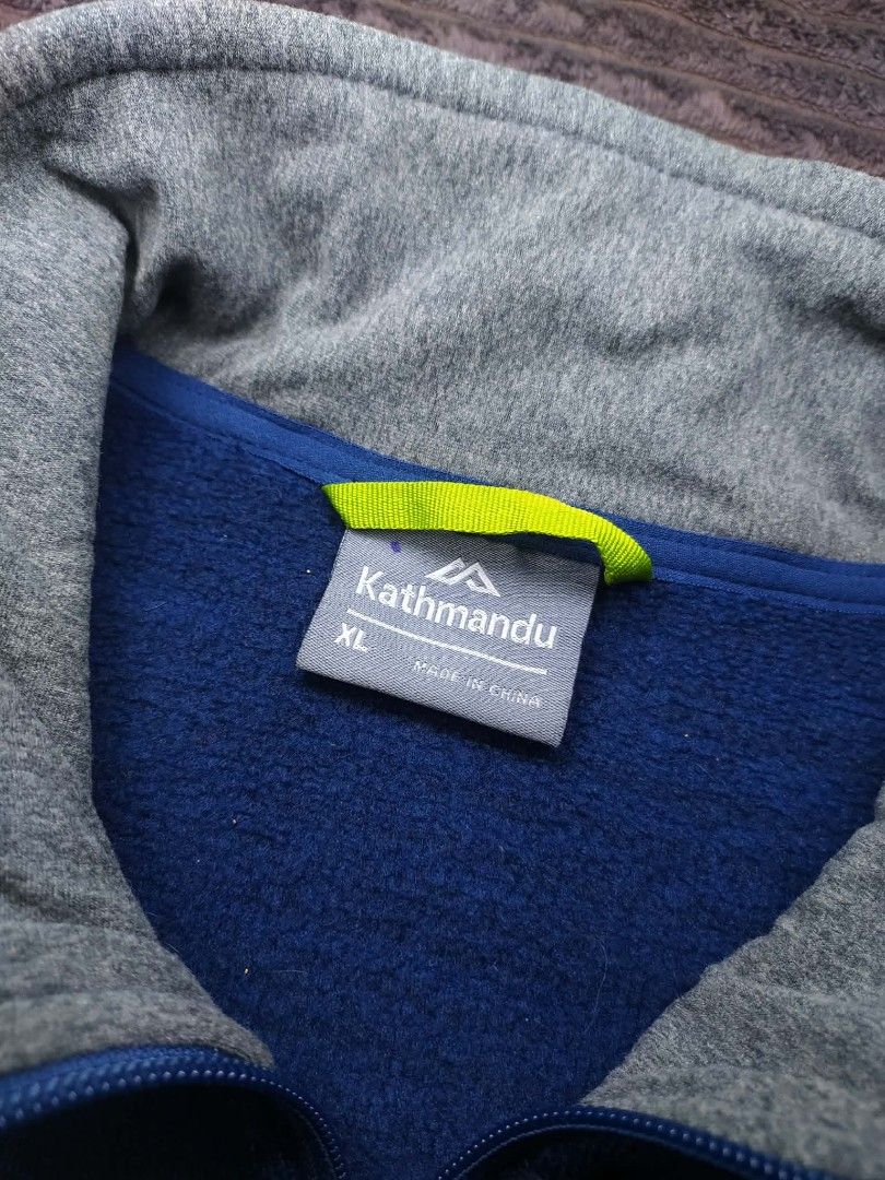 Kathmandu Blue Fleece Jacket XL (Category: Coats, Jackets and Outerwear) located in Manila. Submitted by norathrifted (Listing ID 1464801619, Image 3). Description: - Brand: Kathmandu - Style: Full-zip fleece jacket - Color: Deep blue with grey ribbed inner collar - Logo: White embroidered on chest - Pockets: Two secure zipped side pockets with blue pull cords - Size: XL - Condition: Warm fleece material, perfect outer layer for cold weather.