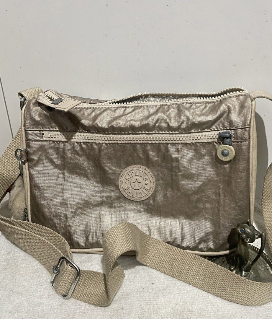 Kipling Bronze Small Sling Bag (Category: Cross-body Bags) located in Antipolo. Submitted by lilhermes (Listing ID 1464866218, Image 1). Description: Wide: 10 inches Height:7.5 inches No bakbak and tear part Fit folded umbrellla.