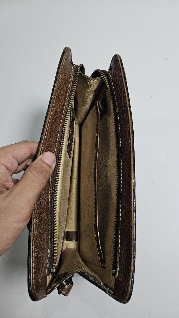Kitamura Brown Leather Long clutch bag (Category: Wallets & Card holders) located in Alfonso. Submitted by jbcamet (Listing ID 1464908499, Image 3). Description: - Authentic Kitamura brown leather clutch bag - Genuine pebbled leather with stylish contrast stitching - Secure snap closure with interior brand tag logo - Exterior zippered pocket on the back for quick access - Multiple card slots, slip pockets, and main compartments for cash and daily