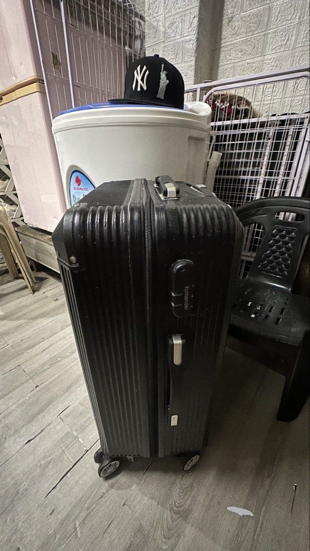 Kumander Black Hard Shell Suitcase Trolley Bag (Category: Luggage) located in Manila. Submitted by maryyy0123 (Listing ID 1464820939, Image 2). Description: Kumander hard case luggage in black. Textured vertical stripes along the body. Reinforced corners for extra durability. Smooth spinner wheels at the base. Retractable top handle for easy pulling. Clean exterior with minor scuffs from previous trips. Zippers run smooth all around. Plenty of sp
