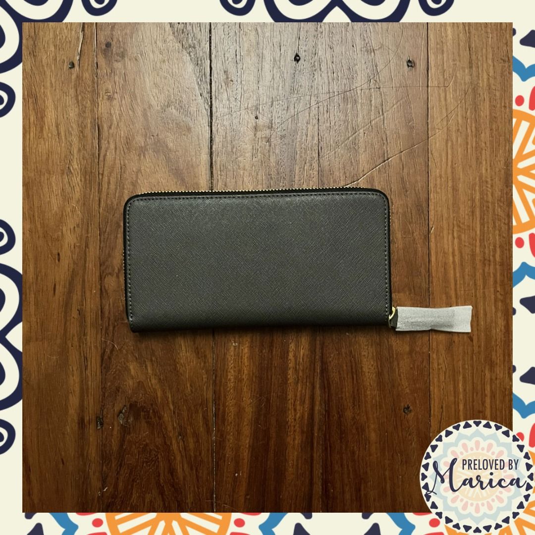 Kurt Geiger Leather Zip Around Wallet (Category: Wallets & Card holders) located in Quezon City. Submitted by mar_ica (Listing ID 1464830575, Image 2). Description: - Brand: Kurt Geiger - Color: Dark grey with elegant gold-tone lettering - Measurements: Length: 20 cm Width: 10.5 cm Depth: 2 cm - Closure: Zip-around with protective paper still on the pull tab - Interior: Multiple card slots, slip compartments, and a zippered coin pocket - Conditio