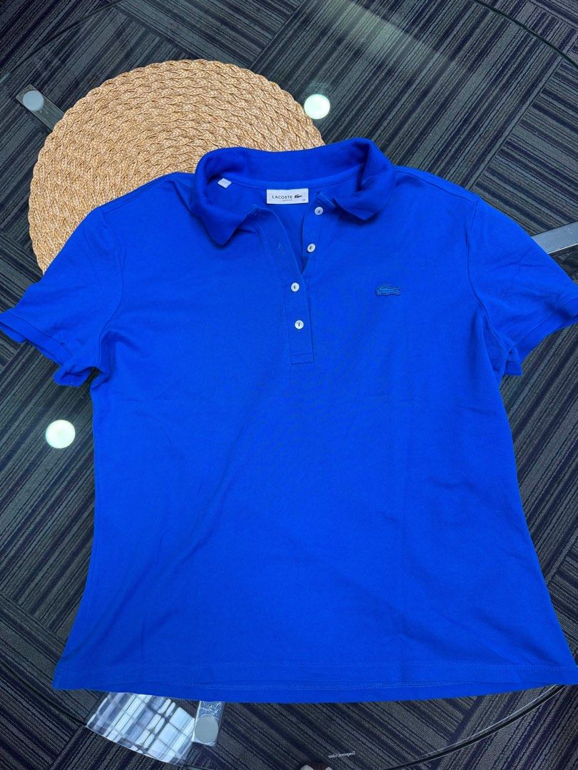 Lacoste Blue Polo Shirt Size 46 (Category: Blouses) located in Caloocan City. Submitted by iwa_017 (Listing ID 1464808453, Image 1). Description: - Brand: Lacoste - Color: Bright Blue - Size: 46 (indicated on collar tag) - Design: Classic short sleeve, front buttons, ribbed collar and armbands - Details: Signature embroidered crocodile logo on the chest - Condition: Clean fabric with neat stitching throughout, great for daily casual wear.