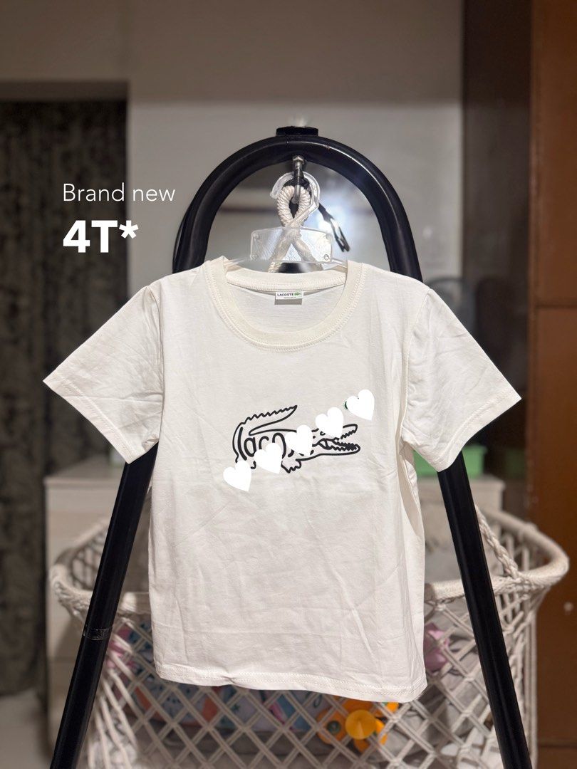 Lacoste White T-Shirt Size 4T (Category: Babies & Kids Fashion) located in Santa Rosa. Submitted by yasss23 (Listing ID 1464837119, Image 1). Description: - Authentic Lacoste kids t-shirt in classic white - Size: 4T (fits toddlers comfortably) - Design: Adorable front graphic featuring the iconic crocodile logo - Material: 100% soft, breathable cotton perfect for daily wear - Style: Short sleeves with a classic round neckline - Condition: Excelle