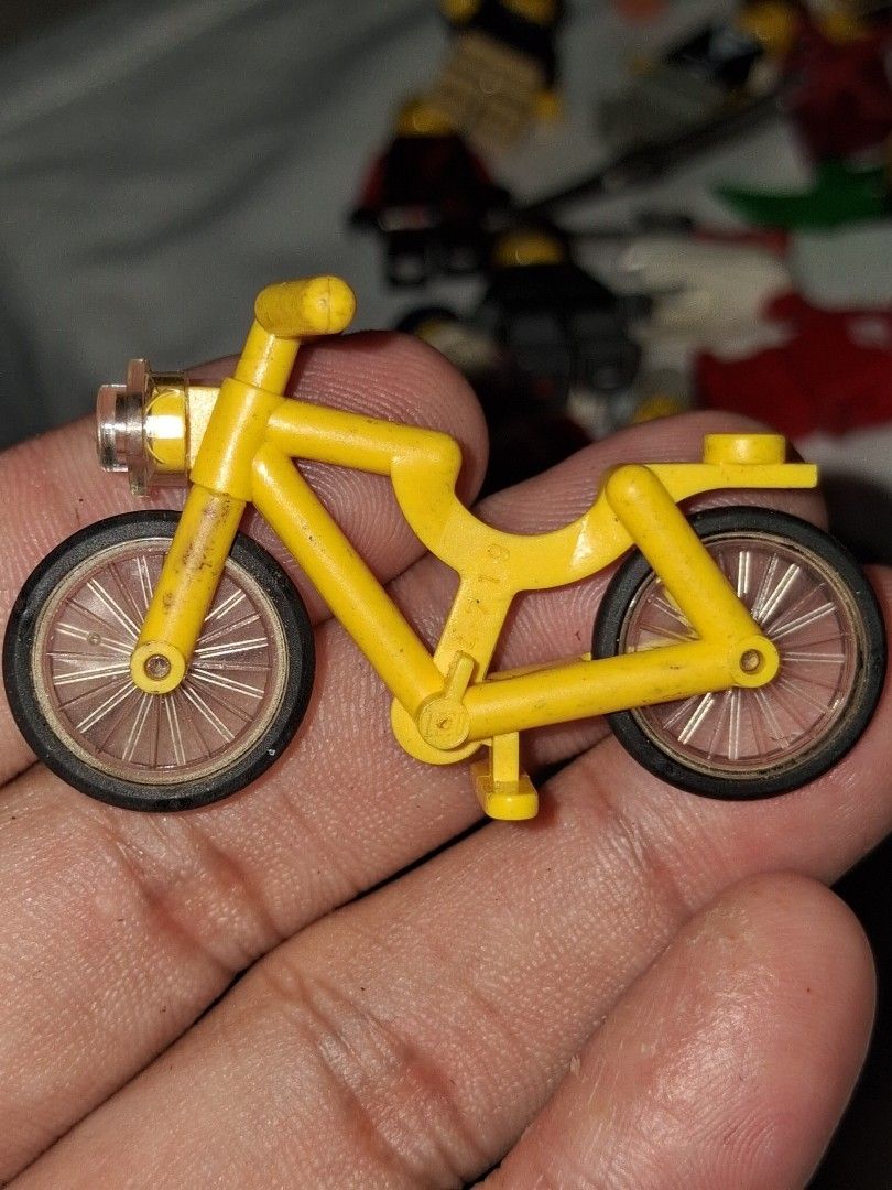 LEGO Yellow Bicycle Accessory Part (Category: Bicycles) located in Manila. Submitted by marcas022798212 (Listing ID 1464875833, Image 1). Description: - Item: Genuine LEGO bicycle piece - Color: Bright yellow frame with black tires and transparent spoked wheels - Features: Molded plastic frame, handlebars, pedals, and connector studs - Condition: Overall intact structure with minor dust from storage - Ideal for: Town layouts and minifigure collec
