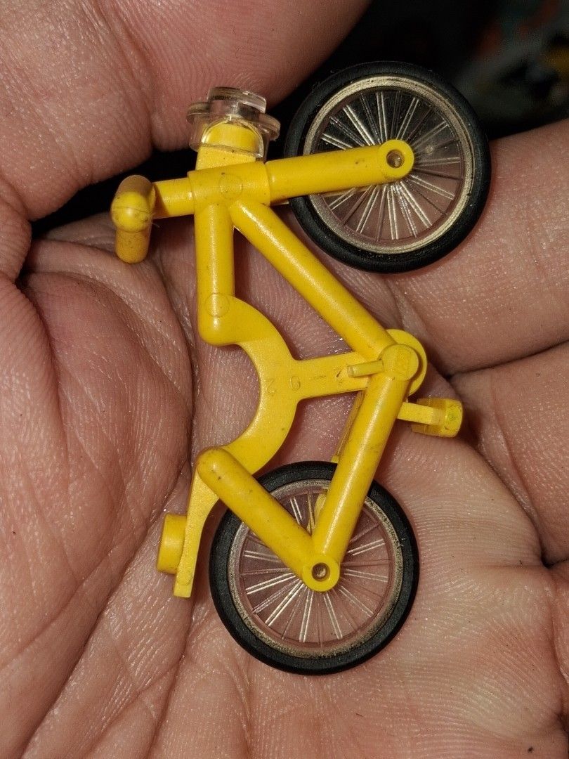 LEGO Yellow Bicycle Accessory Part (Category: Bicycles) located in Manila. Submitted by marcas022798212 (Listing ID 1464875833, Image 2). Description: - Item: Genuine LEGO bicycle piece - Color: Bright yellow frame with black tires and transparent spoked wheels - Features: Molded plastic frame, handlebars, pedals, and connector studs - Condition: Overall intact structure with minor dust from storage - Ideal for: Town layouts and minifigure collec