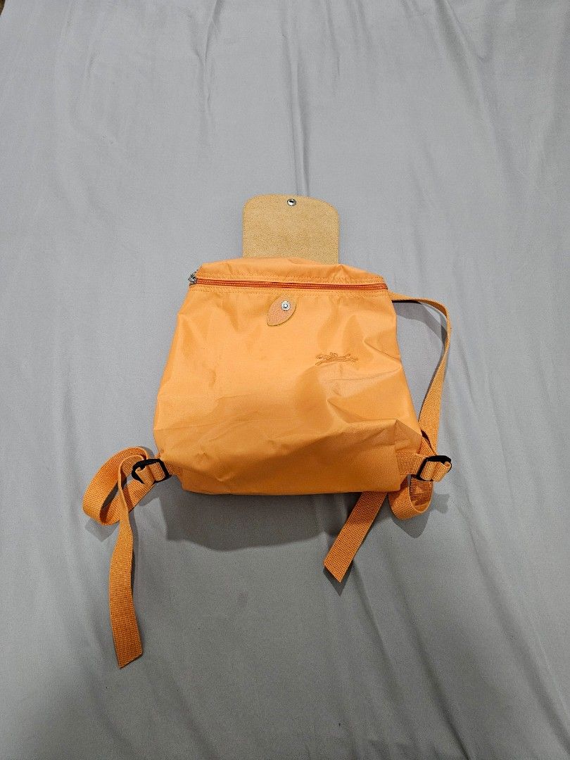 Longchamp Orange Nylon Backpack (Category: Backpacks) located in Mandaluyong City. Submitted by janmarian.ramos (Listing ID 1464827086, Image 3). Description: - Authentic Longchamp backpack in a vibrant bright orange shade - Crafted from durable, lightweight nylon with elegant gold-tone hardware - Features a signature leather front flap with secure snap closure - Zippered main compartment to keep your daily essentials safe - Comfortable, adjustab