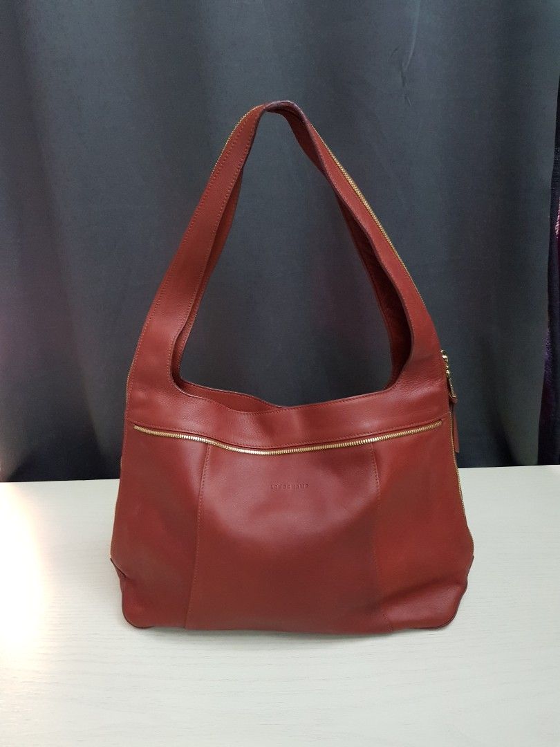 Longchamp Red Leather Shoulder Bag (Category: Luxury Bags & Wallets) located in Mandaluyong City. Submitted by bestill4610 (Listing ID 1464905332, Image 2). Description: Authentic Rare Longchamp Shoulder Bag Nice brick red leather Gold zipper on strap & sides Bought in Rustan's. Never used. L" 16" x H 10" x Base 4".