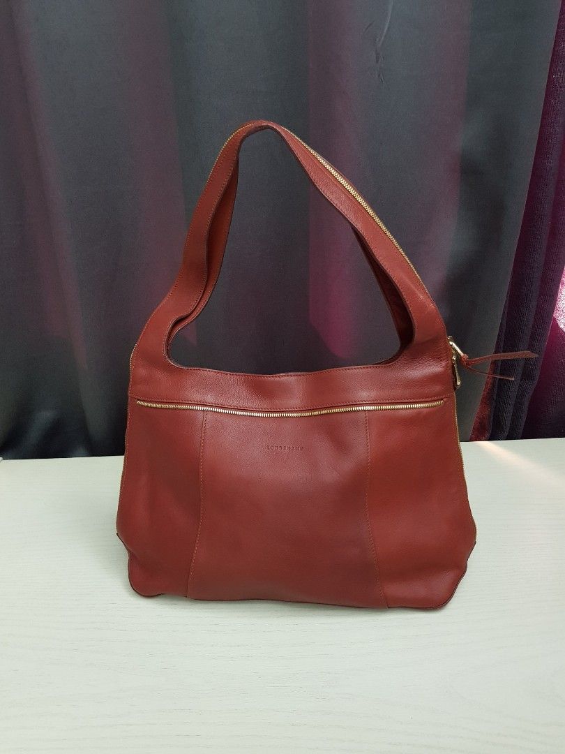 Longchamp Red Leather Shoulder Bag (Category: Luxury Bags & Wallets) located in Mandaluyong City. Submitted by bestill4610 (Listing ID 1464905332, Image 1). Description: Authentic Rare Longchamp Shoulder Bag Nice brick red leather Gold zipper on strap & sides Bought in Rustan's. Never used. L" 16" x H 10" x Base 4".