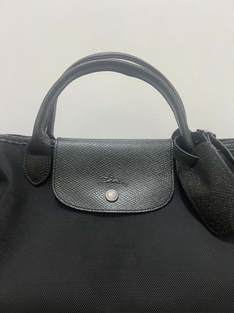 Longchamp Travel Bag Black (Category: Luxury Bags & Wallets) located in Paoay. Submitted by rvf1230 (Listing ID 1464787522, Image 3). Description: - Authentic Longchamp travel bag - Durable black canvas with black leather trim - Silver-toned hardware with signature zipper pull and snap button flap - Roomy interior ideal for weekend trips or carry-on - Dual top handles and detachable shoulder strap with padded wrap - Includes original hanging leat