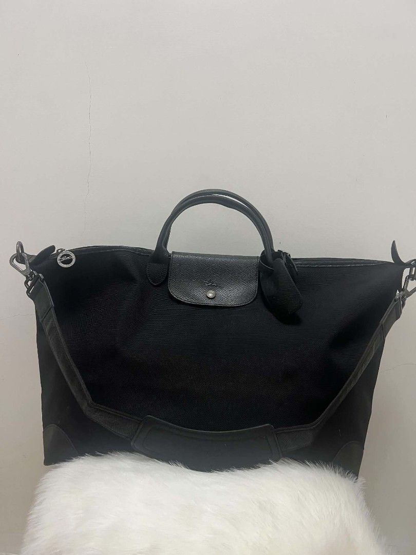 Longchamp Travel Bag Black (Category: Luxury Bags & Wallets) located in Paoay. Submitted by rvf1230 (Listing ID 1464787522, Image 2). Description: - Authentic Longchamp travel bag - Durable black canvas with black leather trim - Silver-toned hardware with signature zipper pull and snap button flap - Roomy interior ideal for weekend trips or carry-on - Dual top handles and detachable shoulder strap with padded wrap - Includes original hanging leat