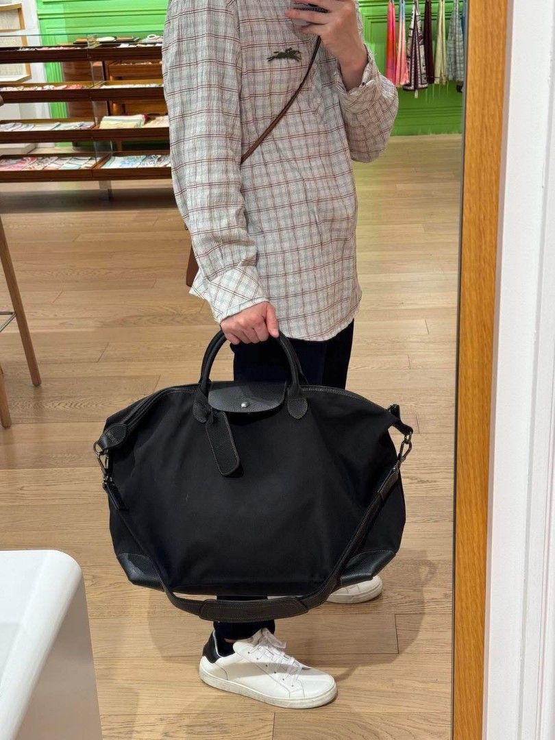 Longchamp Travel Bag Black (Category: Luxury Bags & Wallets) located in Paoay. Submitted by rvf1230 (Listing ID 1464787522, Image 1). Description: - Authentic Longchamp travel bag - Durable black canvas with black leather trim - Silver-toned hardware with signature zipper pull and snap button flap - Roomy interior ideal for weekend trips or carry-on - Dual top handles and detachable shoulder strap with padded wrap - Includes original hanging leat