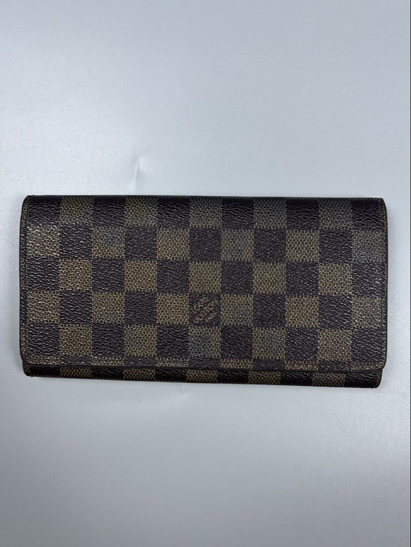 Louis Vuitton Damier Ebene Long Wallet (Category: Luxury Bags & Wallets) located in Mabalacat. Submitted by doughnutthrift (Listing ID 1464888809, Image 1). Description: - Louis Vuitton long wallet in classic Damier Ebene brown checkerboard canvas - Features gold-tone hardware, multiple card slots, and a secure zippered coin compartment - Clear date code stamped inside for authenticity - Exterior canvas is in great, well-kept condition - Normal p