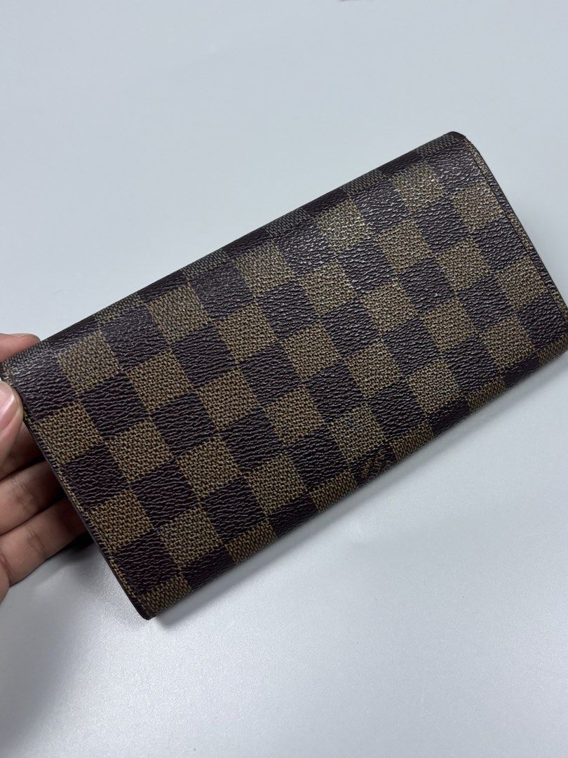 Louis Vuitton Damier Ebene Long Wallet (Category: Luxury Bags & Wallets) located in Mabalacat. Submitted by doughnutthrift (Listing ID 1464888809, Image 3). Description: - Louis Vuitton long wallet in classic Damier Ebene brown checkerboard canvas - Features gold-tone hardware, multiple card slots, and a secure zippered coin compartment - Clear date code stamped inside for authenticity - Exterior canvas is in great, well-kept condition - Normal p