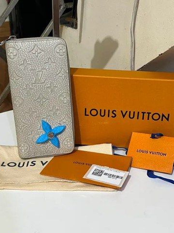 Louis Vuitton Zippy Monogram Empreinte Wallet (Category: Wallets & Card holders) located in Quezon City. Submitted by luxuriesbymichiika (Listing ID 1464924664, Image 1). Description: Louis Vuitton zippy wallet in light grey embossed leather with silver hardware. Bright blue interior lining and matching detachable flower charm attached to the front zipper pull. Full zip-around closure, multiple card slots, and spacious compartments inside. Includ