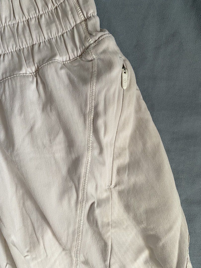 Lululemon High-Rise Track Shorts (Category: Shorts) located in Manila. Submitted by heyheyruok (Listing ID 1464797413, Image 2). Description: Lululemon Track That Short 5". High-rise waist with a wide elastic band. Soft neutral beige colorway. Built-in liner shorts inside. Secure zipper pocket on the side seam. Reflective logo detail near the bottom hem. Size 12 tag attached inside. Great everyday workout short..