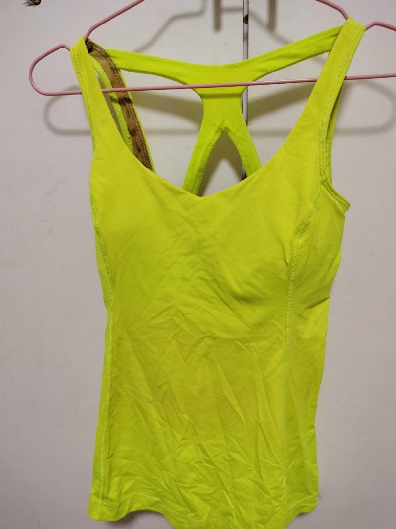 Lululemon Optimal Tank Neon Yellow Size 4 (Category: Sleeveless) located in San Mateo. Submitted by shop_with_nicer (Listing ID 1464823958, Image 3). Description: - Brand: Lululemon - Color: Bright neon yellow - Features: Built-in bra with brown polka dot lining, unique criss-cross back straps, and reflective logo - Fabric: Stretchy, breathable, and comfortable - Ideal for: Gym workouts, runs, and yoga classes - Condition: Great pre-loved conditi
