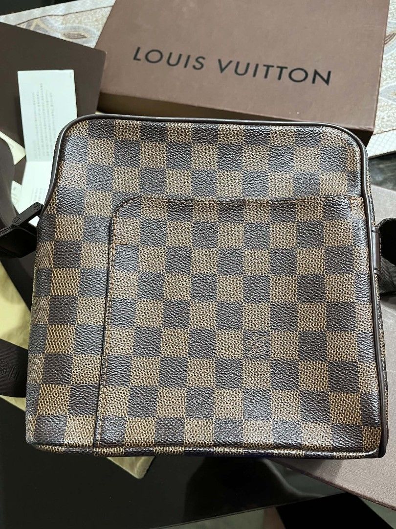 LV damier ebene olav (Category: Luxury Bags & Wallets) located in Trece Martires City. Submitted by vherma (Listing ID 1464774714, Image 2). Description: Louis Vuitton Damier Ebene Olav Messenger Bag, featuring the brand's iconic brown checkerboard canvas and an exterior slip pocket. Key Details Brand: Louis Vuitton Pattern: Damier Ebene Canvas Style: Olav (Messenger / Crossbody) Features: Brown checkered coated canvas, dark brown adjustable fabr