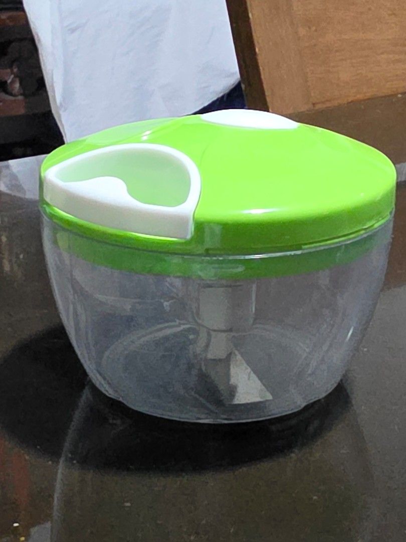 Manual pull cord food chopper with green lid (Category: Cookware & Accessories) located in Caloocan City. Submitted by bravemountain_ddc4bf (Listing ID 1464938580, Image 1). Description: - Item: Manual pull-cord food chopper - Color/Material: Clear plastic bowl with a green lid - Blades: Sharp stainless steel blades with central white spindle - Condition: Fully functional gear mechanism, but please note there is a visible crack along the side of 
