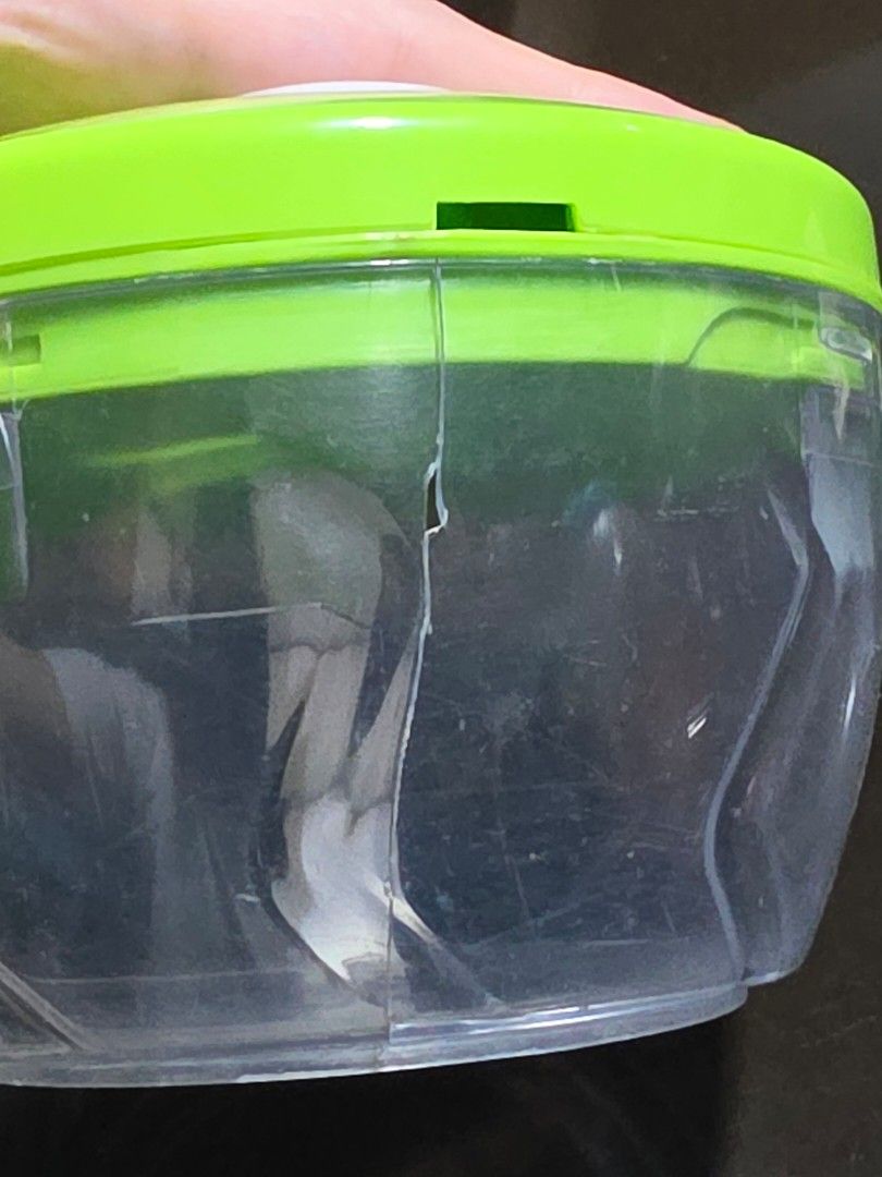 Manual pull cord food chopper with green lid (Category: Cookware & Accessories) located in Caloocan City. Submitted by bravemountain_ddc4bf (Listing ID 1464938580, Image 3). Description: - Item: Manual pull-cord food chopper - Color/Material: Clear plastic bowl with a green lid - Blades: Sharp stainless steel blades with central white spindle - Condition: Fully functional gear mechanism, but please note there is a visible crack along the side of 