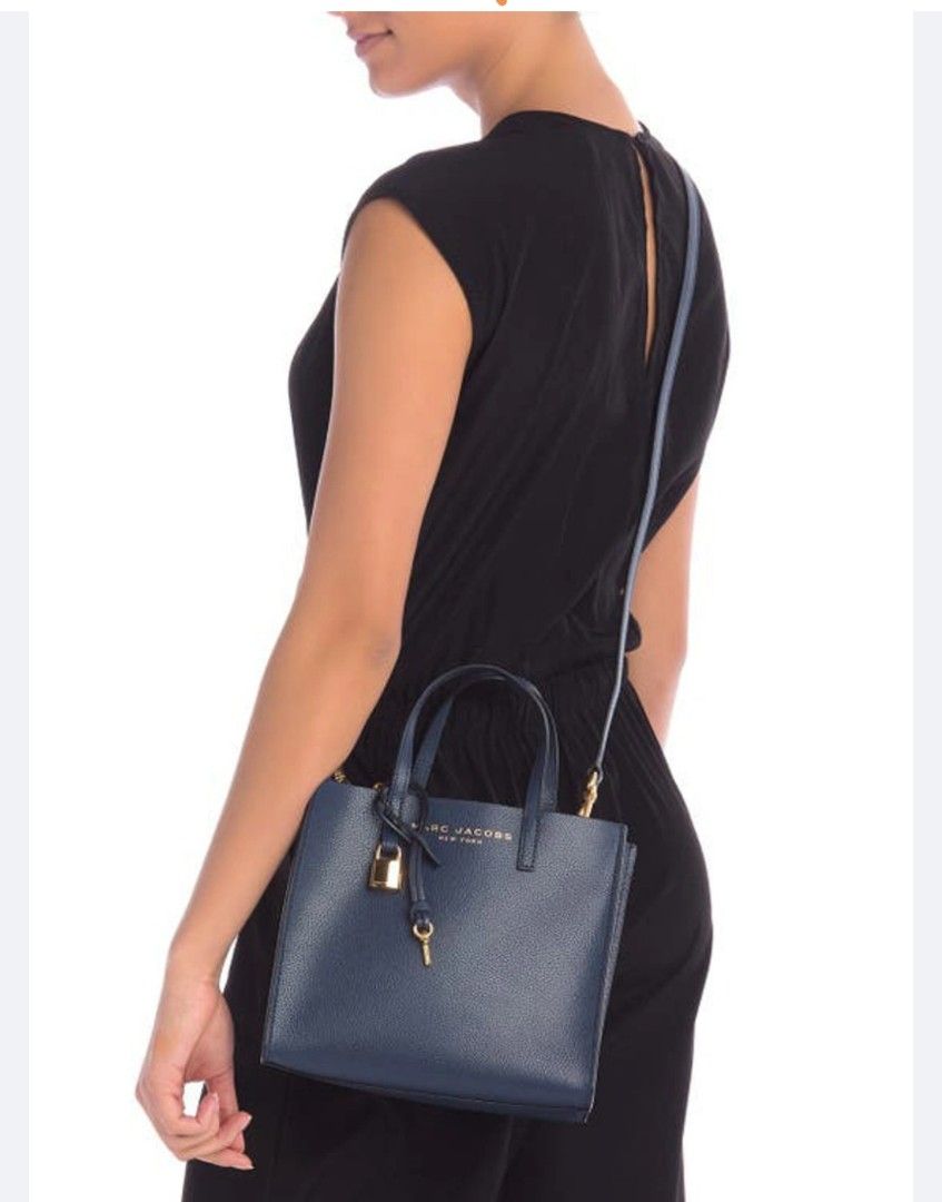 Marc Jacobs Leather Mini Grind Tote Bag Blue (Category: Tote Bags) located in Antipolo. Submitted by gievan0725 (Listing ID 1464864195, Image 1). Description: - Brand: Marc Jacobs - Style: Mini Grind Tote - Material: Textured blue leather - Hardware: Gold-tone with hanging padlock and key charm - Compartments: Zip top center compartment with open side sections and printed lining - Straps: Dual top handles and a detachable, adjustable crossbody st