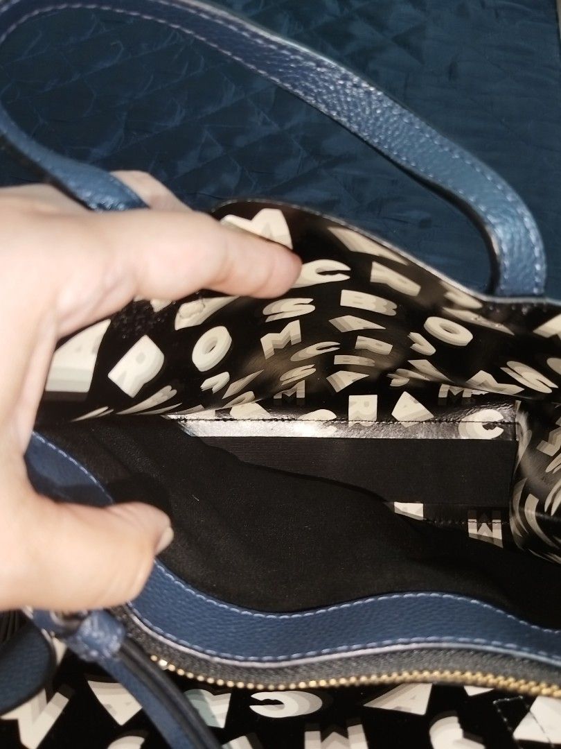 Marc Jacobs Leather Mini Grind Tote Bag Blue (Category: Tote Bags) located in Antipolo. Submitted by gievan0725 (Listing ID 1464864195, Image 3). Description: - Brand: Marc Jacobs - Style: Mini Grind Tote - Material: Textured blue leather - Hardware: Gold-tone with hanging padlock and key charm - Compartments: Zip top center compartment with open side sections and printed lining - Straps: Dual top handles and a detachable, adjustable crossbody st