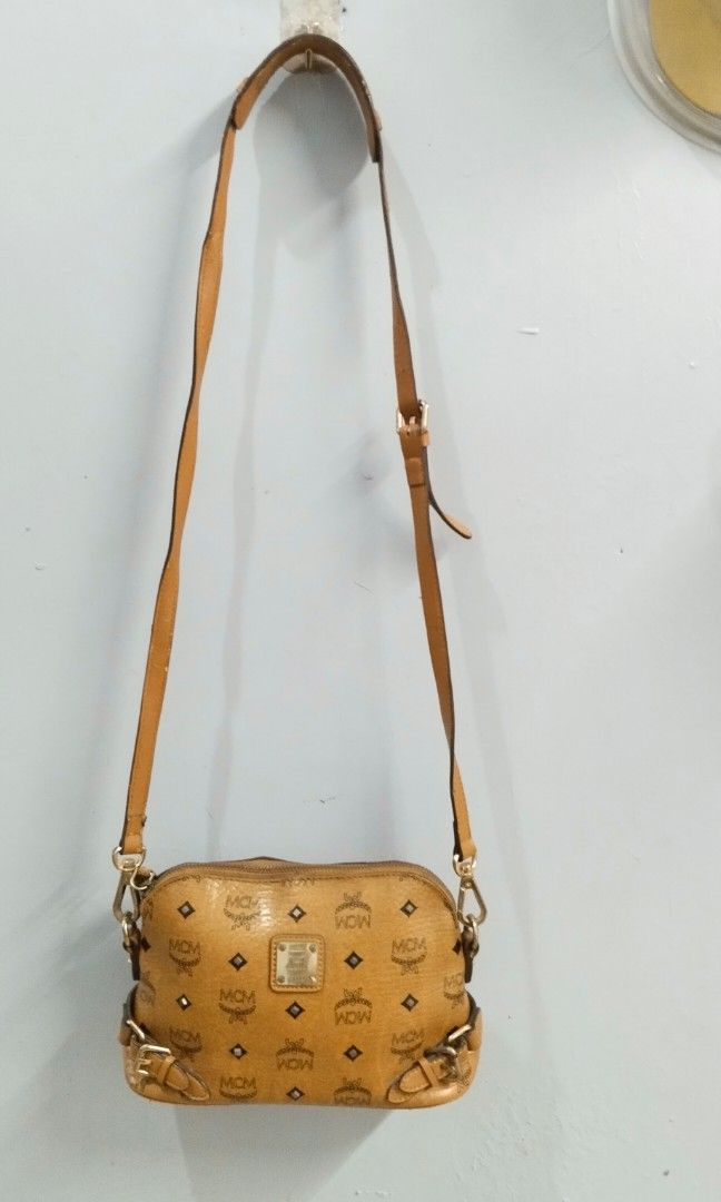 MCM visetos crossbody bag (Category: Luxury Bags & Wallets) located in Trece Martires City. Submitted by vherma (Listing ID 1464771560, Image 2). Description: The selected region appears to show a brown and tan monogram MCM Visetos Crossbody Bag featuring a signature diamond monogram print, gold-tone hardware, an adjustable shoulder strap, and a front logo plaque. Bag Features MCM monogram coated canvas body in cognac tan. Gold-tone metal hardwar