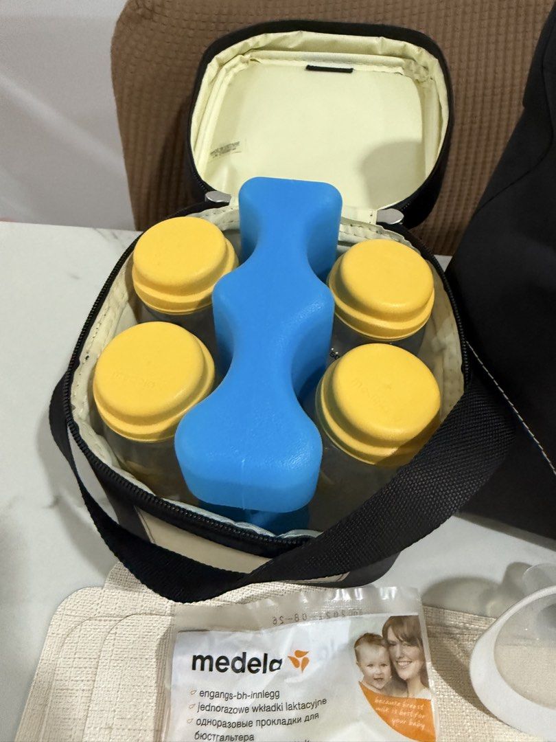 Medela Freestyle Double Electric Breast Pump Set (Category: Breastfeeding & Bottle Feeding) located in Manila. Submitted by ainamc (Listing ID 1464811576, Image 2). Description: - Complete Medela Freestyle breast pump set for pumping on the go - Includes motor unit with strap, main black tote bag, and cooler bag - Comes with 4 milk bottles, yellow caps, and a contoured blue ice pack - Multiple breast shields in various sizes, connector pieces, an