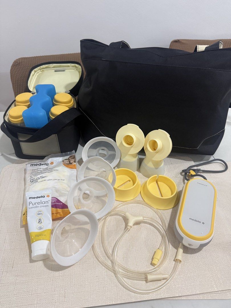Medela Freestyle Double Electric Breast Pump Set (Category: Breastfeeding & Bottle Feeding) located in Manila. Submitted by ainamc (Listing ID 1464811576, Image 1). Description: - Complete Medela Freestyle breast pump set for pumping on the go - Includes motor unit with strap, main black tote bag, and cooler bag - Comes with 4 milk bottles, yellow caps, and a contoured blue ice pack - Multiple breast shields in various sizes, connector pieces, an